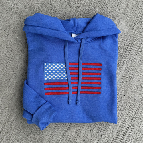 Blue hoodie with American flag design on a gray surface