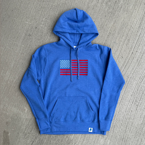 Blue hoodie with American flag design on a gray surface