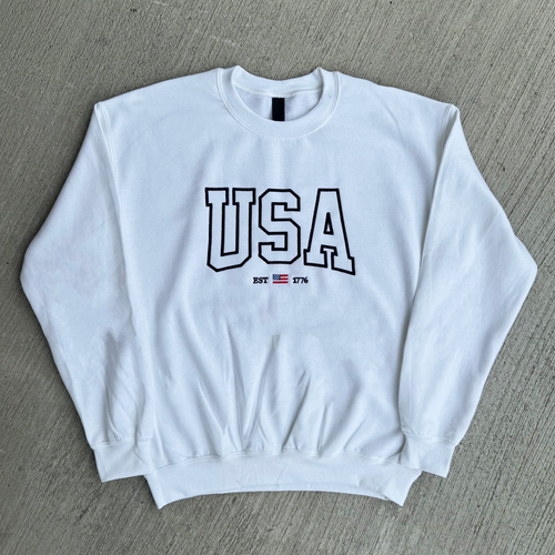 White sweatshirt with 'USA' text on a gray surface