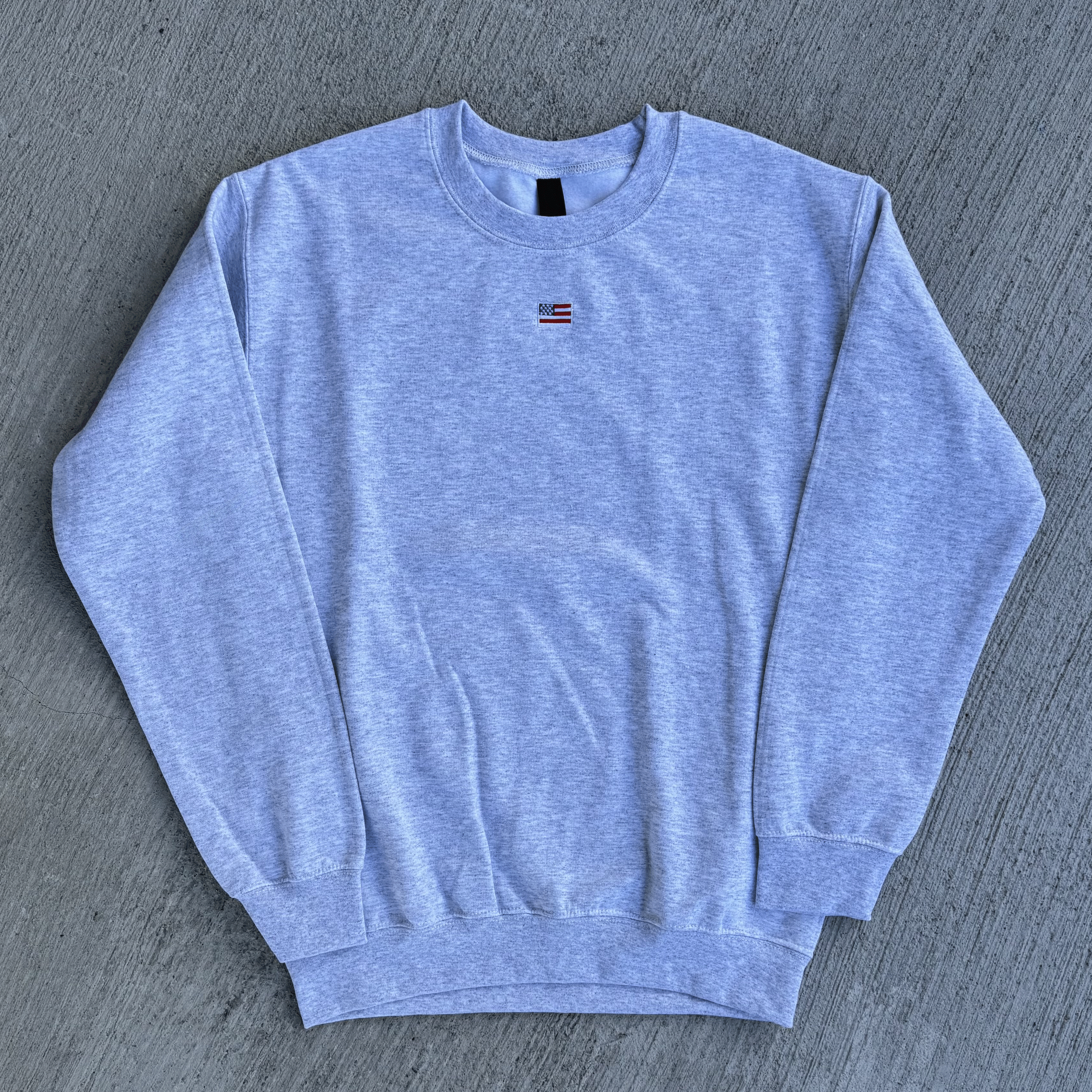 Gray sweatshirt with a small logo on a gray textured background