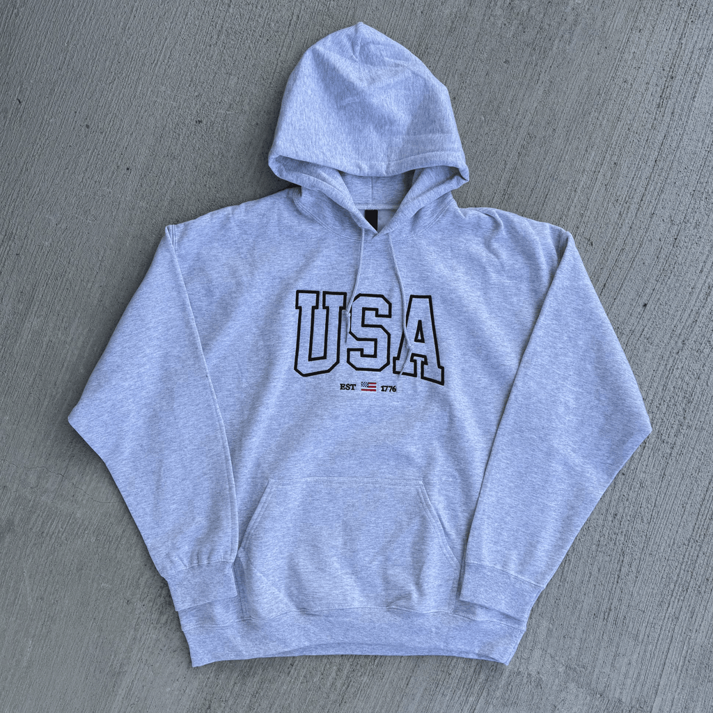 Gray hoodie with 'USA' text on a gray surface